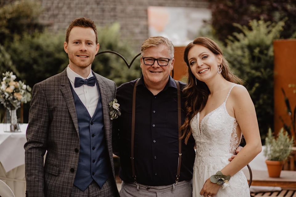 Hochzeitspärchen mit einem Hochzeitsredner in der Natur